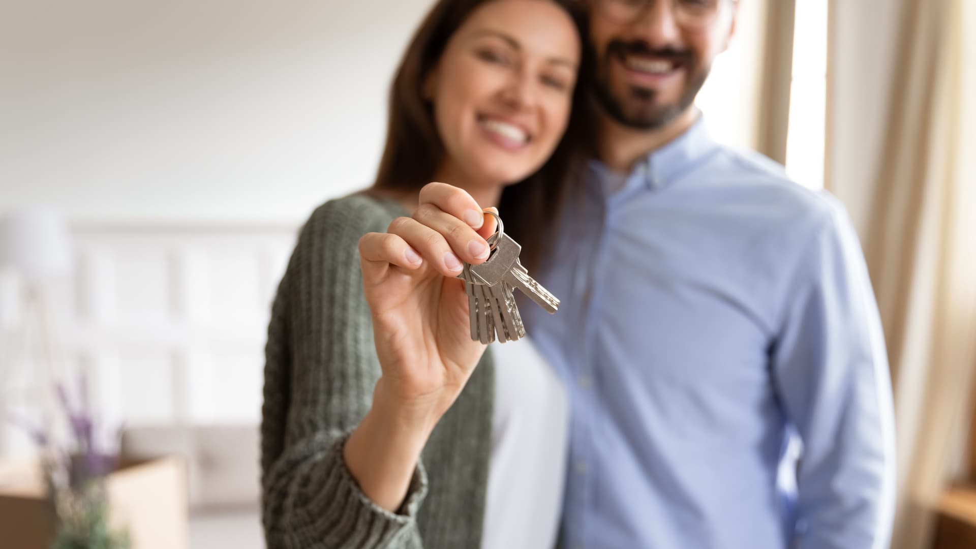 New homeowner reviewing a home maintenance checklist at a kitchen table with house keys and a cup of coffee nearby