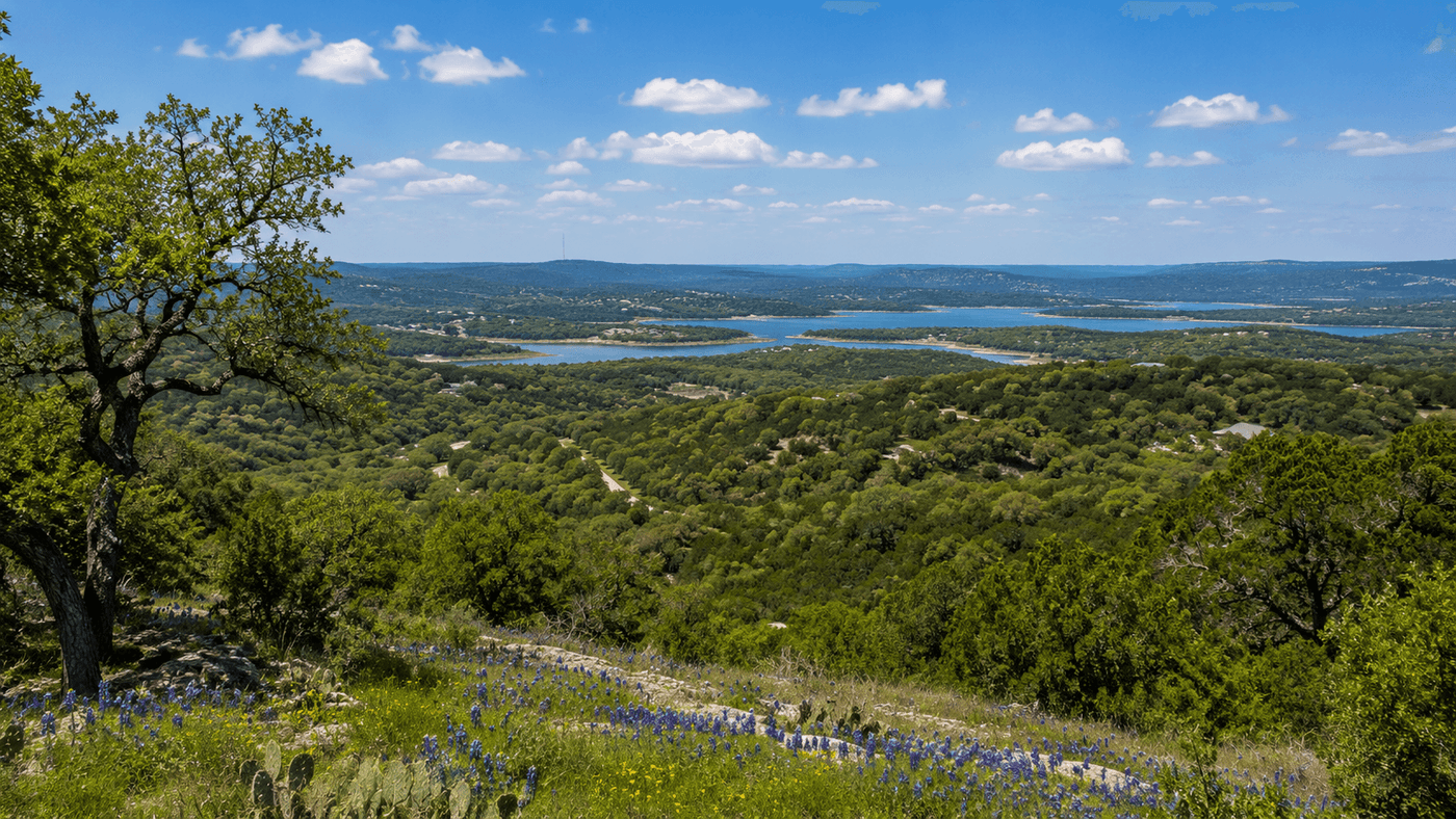 A panoramic view of the Texas Hill Country near Burnet, with rolling oak-covered hills and the Highland Lakes visible in the distance.