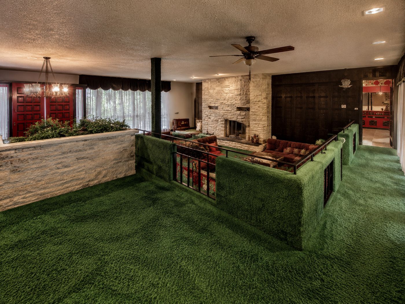 Retro 1970s sunken living room with masonry fireplace and pink carpeting