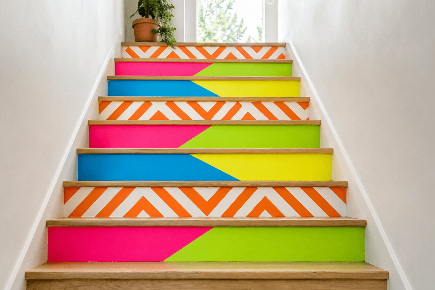 Staircase with bold neon geometric painted risers in electric pink, lime green, bright orange, and electric blue with diagonal color blocks and chevron patterns on each riser, neutral wood treads above, viewed from the bottom of the stairs