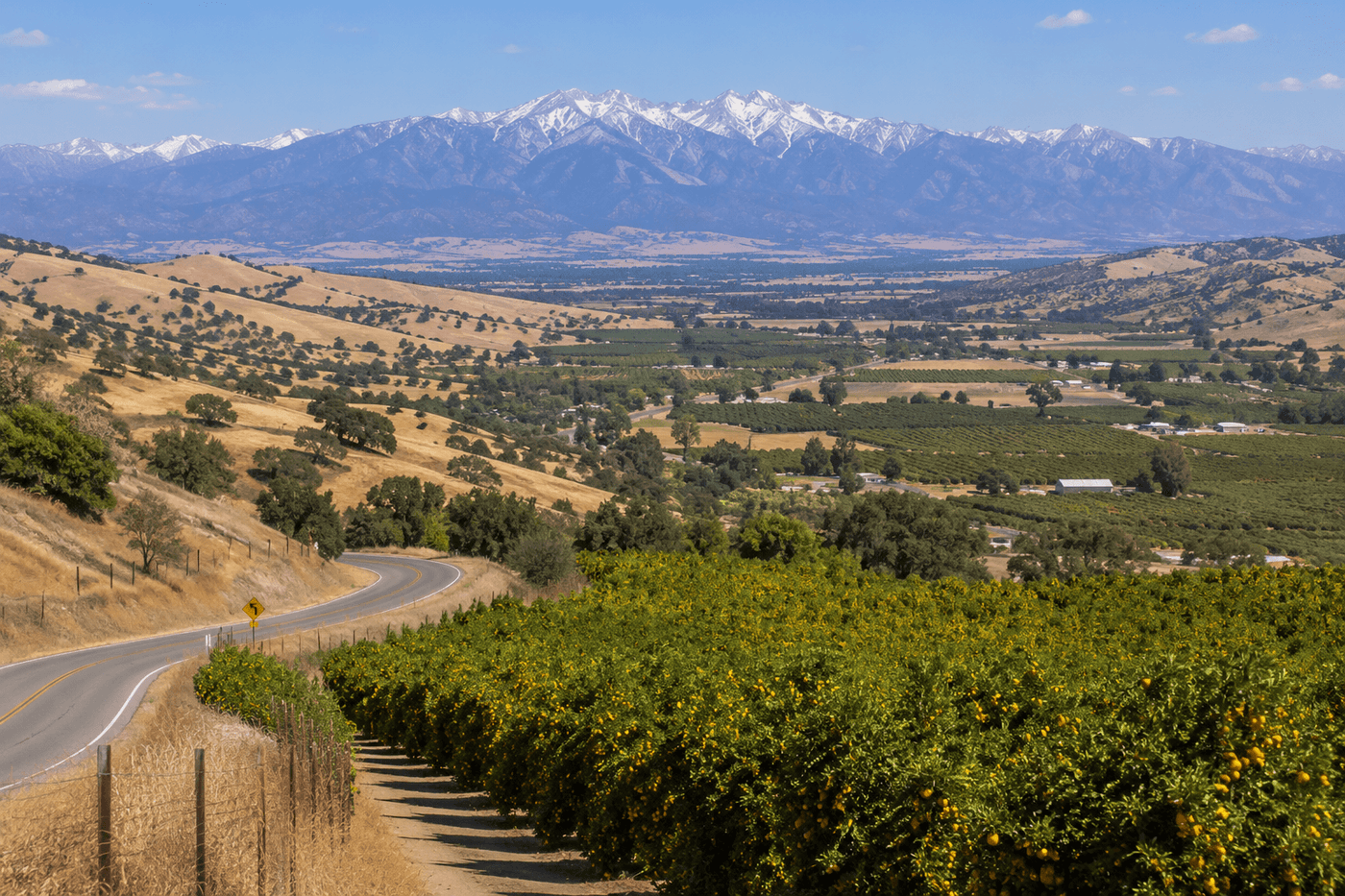 The California foothills near Porterville in Tulare County, with rolling golden hills, citrus groves, and the Sierra Nevada visible in the distance.